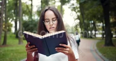 女学生在公园散步和看书